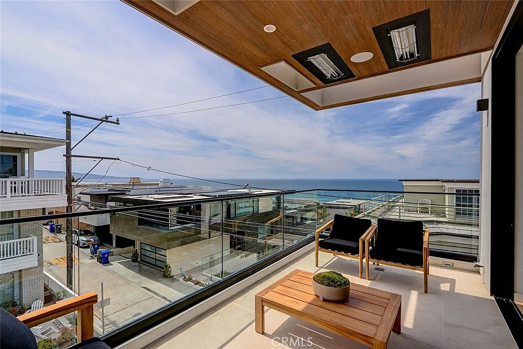 Top-floor balcony with protected ocean view through glass railing and teak ceiling