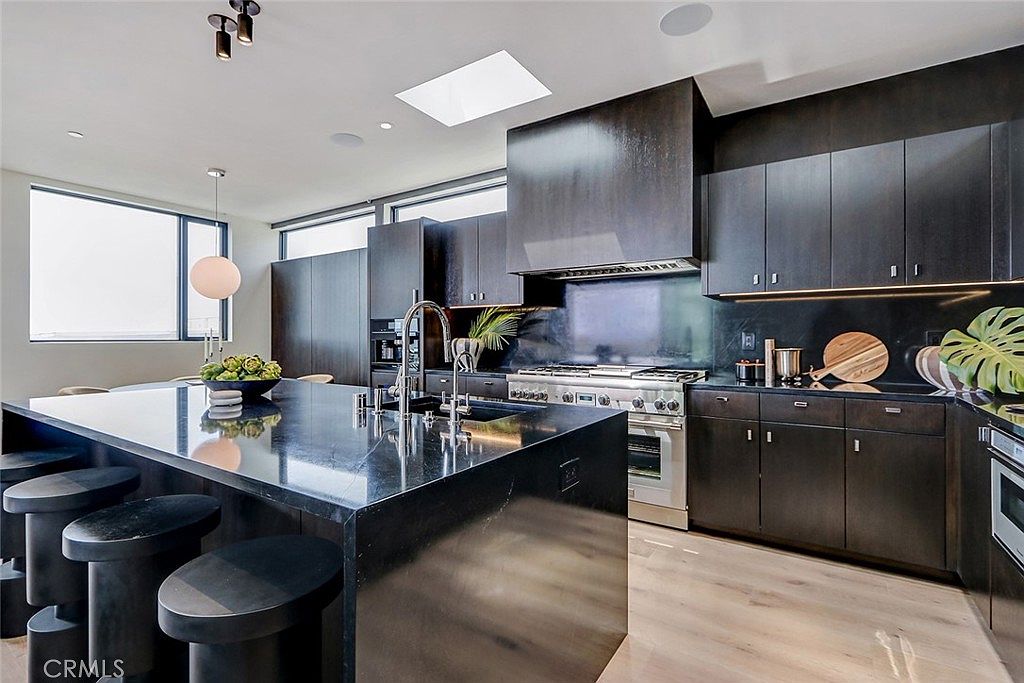 Kitchen with espresso-stained cabinetry, Saratoga soapstone island, and natural oak floors