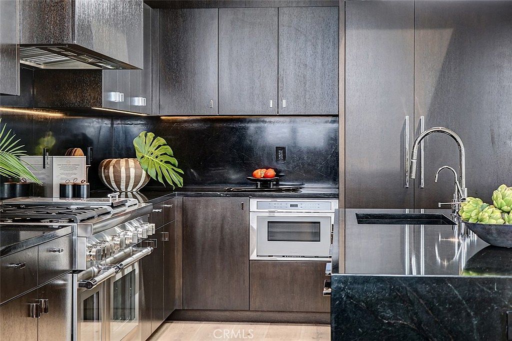 Detail of espresso millwork with monstera plant and integrated appliance