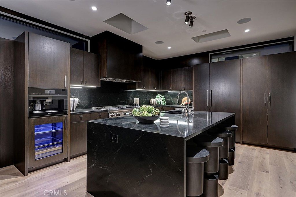 Kitchen wide view with island, dark cabinetry and recessed lighting